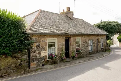 an old stone house on the side of a road at Romantic cottage with fantastic coastal views in Marazion