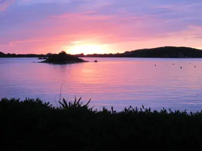 a sunset over a large body of water at Romantic cottage with fantastic coastal views in Marazion