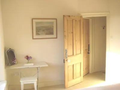 a room with a door and a table and a chair at Romantic cottage with fantastic coastal views in Marazion