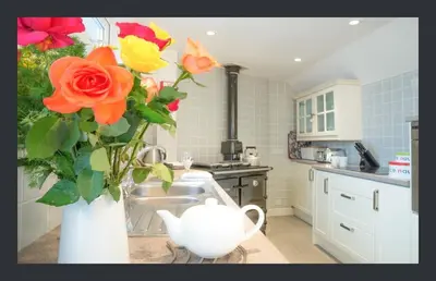a kitchen with a vase with flowers in it at No 11 Fish Street, St Ives in St Ives