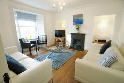 a living room with two white couches and a fireplace at No 11 Fish Street, St Ives in St Ives