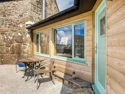 a patio with a table and chairs and a window at Cottage Uk48457 in St Ives