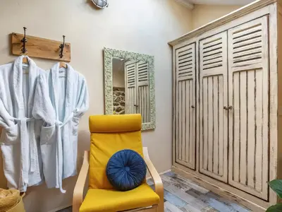 a bathroom with a yellow chair and a mirror at Cottage Uk48457 in St Ives