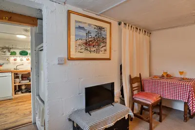 a living room with a fireplace and a table at Finest Retreats - The Noel at Lesceave in Praa Sands