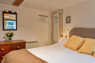 a bedroom with a bed and a dresser and a mirror at Finest Retreats - The Noel at Lesceave in Praa Sands