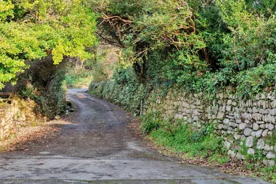 a dirt road next to a stone wall at Finest Retreats - The Noel at Lesceave in Praa Sands