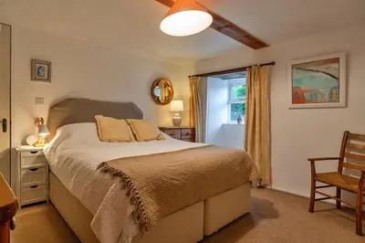 a bedroom with a bed and a chair and a window at Finest Retreats - The Noel at Lesceave in Praa Sands