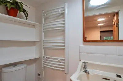 a bathroom with a sink and a toilet and a mirror at Finest Retreats - The Noel at Lesceave in Praa Sands