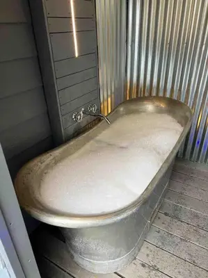 a dirty bath tub sitting in a room at Newly Refurbished Beach Lodge in Looe