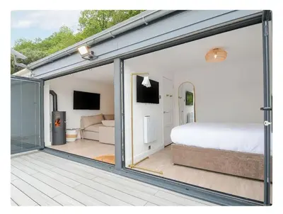 a room with a bed and a sliding glass door at Newly Refurbished Beach Lodge in Looe