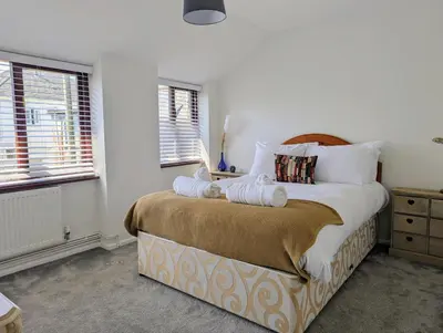 a bedroom with a large bed with towels on it at The Old Barn near St Ives - Rustic Charm & Space in St Ives