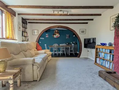 a living room with a couch and a table at The Old Barn near St Ives - Rustic Charm & Space in St Ives