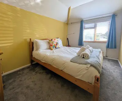 a bedroom with a bed with a dog laying on it at The Old Barn near St Ives - Rustic Charm & Space in St Ives