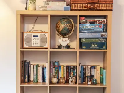 a book shelf with a microwave and a globe on it at Owl Cottage in Looe