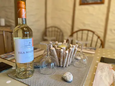 a bottle of wine sitting on top of a table at Carole's Cottage - Private Parking, Sea Views, Garden & Close To Harbour & Beach in Charlestown