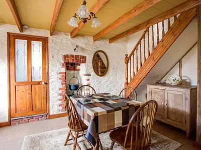 a dining room with a table and four chairs at Carole's Cottage - Private Parking, Sea Views, Garden & Close To Harbour & Beach in Charlestown