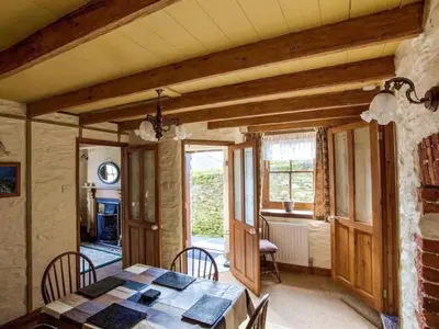 a dining room with a table and chairs at Carole's Cottage - Private Parking, Sea Views, Garden & Close To Harbour & Beach in Charlestown