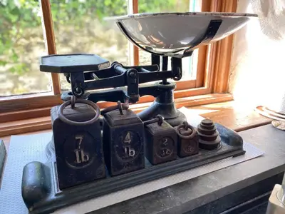 a scale sitting on a table next to a window at Carole's Cottage - Private Parking, Sea Views, Garden & Close To Harbour & Beach in Charlestown