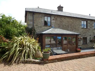 a house with a conservatory in front of it at Little Hendra at Hendra Barns in Newquay
