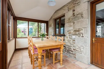 a dining room with a wooden table and chairs at Little Hendra at Hendra Barns in Newquay