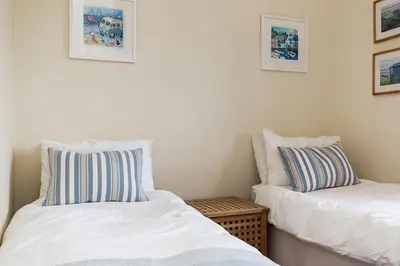 two beds sitting next to each other in a room at Little Hendra at Hendra Barns in Newquay