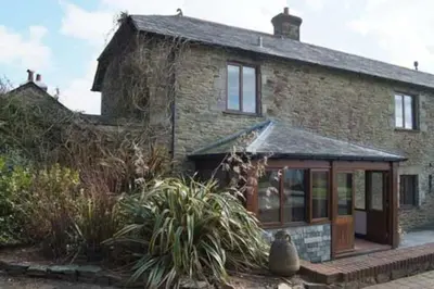 an old brick house with a conservatory in front of it at Little Hendra at Hendra Barns in Newquay
