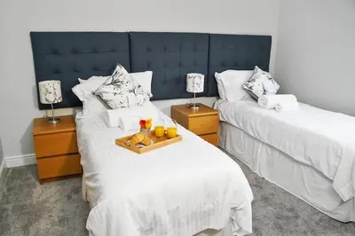 a bedroom with two beds with a tray of fruit at Lux Hot Tub Lodge, Retallack nr Padstow and Newquay in Padstow