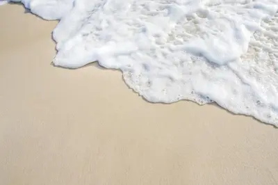 a close up of the ocean foam on the beach at Lux Hot Tub Lodge, Retallack nr Padstow and Newquay in Padstow