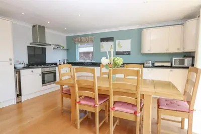 a kitchen with a wooden dining room table and chairs at Lux Hot Tub Lodge, Retallack nr Padstow and Newquay in Padstow