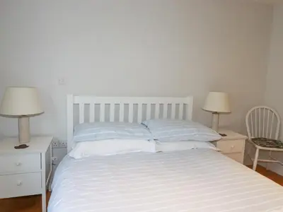 a white bed with two night stands and two lamps at Freefolk in Wadebridge