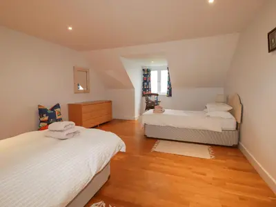 a bedroom with two beds and a wooden floor at Freefolk in Wadebridge