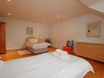 a bedroom with two beds and a mirror at Freefolk in Wadebridge