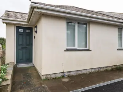 a house with a green door and two windows at Freefolk Cottage in Wadebridge