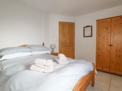 a bedroom with a bed with towels on it at Freefolk Cottage in Wadebridge