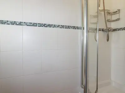 a bathroom with a shower with a glass door at Freefolk Cottage in Wadebridge