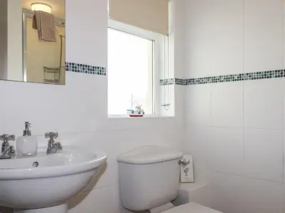 a white bathroom with a toilet and a sink at Freefolk Cottage in Wadebridge