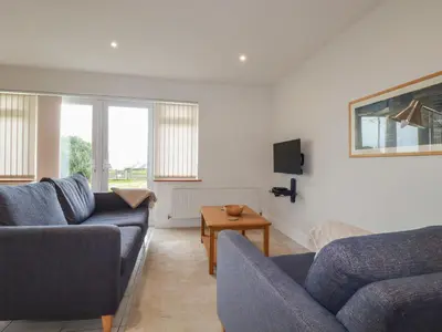 a living room with two couches and a table at Freefolk Cottage in Wadebridge