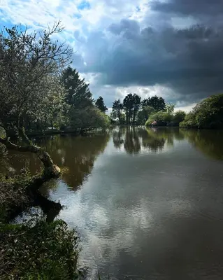 a view of a river with a cloudy sky at Greenfinch Lakeside Bell Tent Basic with Airbeds Only in Saint Columb Major