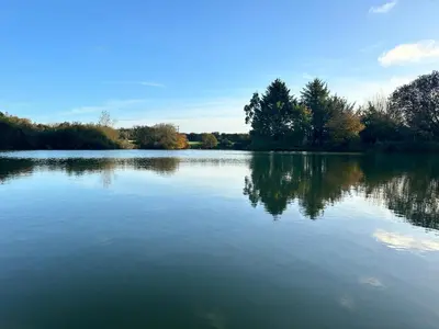 a large body of water with trees in the background at Greenfinch Lakeside Bell Tent Basic with Airbeds Only in Saint Columb Major