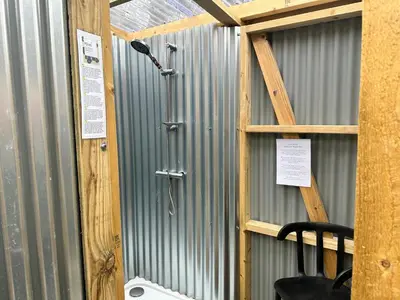 a metal wall with a shower in a building at Greenfinch Lakeside Bell Tent Basic with Airbeds Only in Saint Columb Major