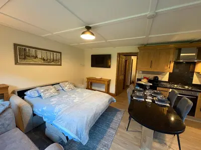 a bedroom with a bed and a table in it at Jasmine cottage in Liskeard