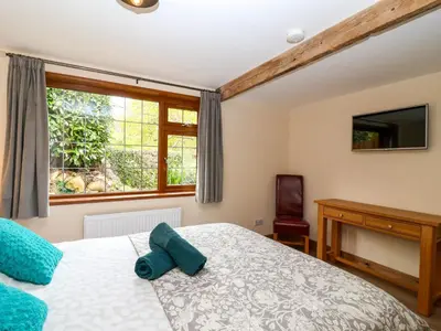 a bedroom with a bed and a window at Jasmine cottage in Liskeard