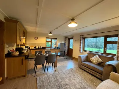 a kitchen and living room with a couch and a table at Jasmine cottage in Liskeard
