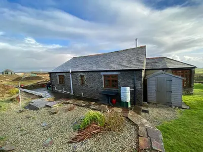 a small brick house with a grassy yard at Sundance Cottage Sleeps 4 in Camelford