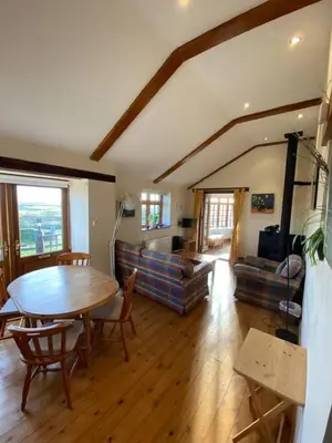 a living room with a table and a couch at Sundance Cottage Sleeps 4 in Camelford