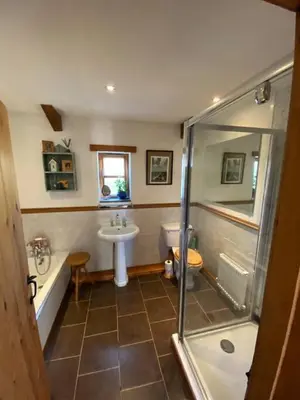 a bathroom with a shower and a sink and a tub at Sundance Cottage Sleeps 4 in Camelford