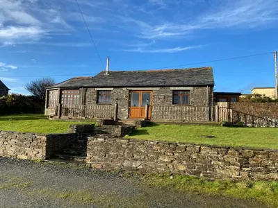 a stone house with a stone wall at Sundance Cottage Sleeps 4 in Camelford
