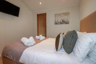 a bedroom with a bed with white sheets and pillows at 3 Hedgerows in Looe