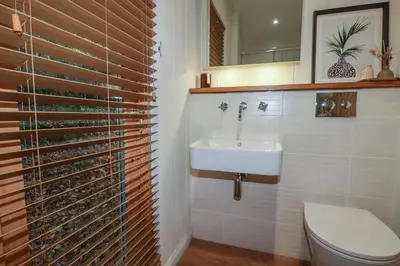 a bathroom with a sink and a toilet and a mirror at 3 Hedgerows in Looe