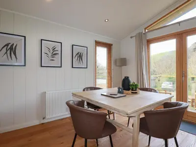 a dining room with a wooden table and chairs at 3 Hedgerows in Looe